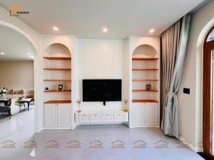 un salon avec une télévision à écran plat sur un mur dans l'établissement Bi Home, à Phú Mỹ