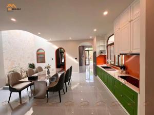 une cuisine avec une grande table à manger et des chaises dans l'établissement Bi Home, à Phú Mỹ