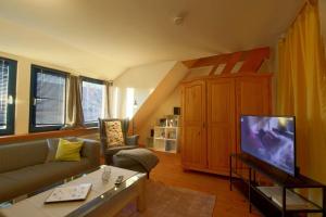 a living room with a couch and a tv at KA6 Haus Küstenzeit in Wremen