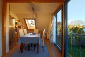 a kitchen and dining room with a table and a large window at KA6 Haus Küstenzeit in Wremen