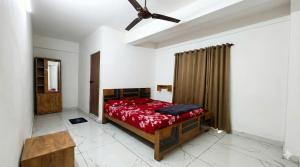 a bedroom with a bed and a ceiling fan at SAIS LINE Residency in Kozhikode +5 photos