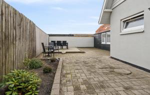 a patio with chairs and a fence at Nice Home In Thyborøn With Wifi in Thyborøn +15 photos