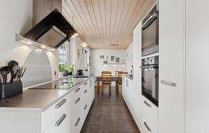 a kitchen with white cabinets and a dining room at Nice Home In Thyborøn With Wifi in Thyborøn