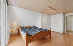 a bedroom with a bed in the corner of a room at Nice Home In Thyborøn With Wifi in Thyborøn