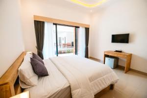 een slaapkamer met een groot bed en een raam bij Kubu Dangin Guest House Kerobokan in Seminyak