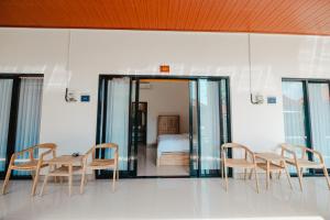 een kamer met een tafel en stoelen en een bed bij Kubu Dangin Guest House Kerobokan in Seminyak +21 foto's
