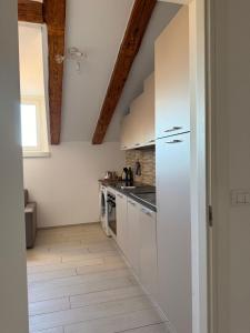 a kitchen with white appliances and wooden ceilings at CELLINI HOME in Trieste