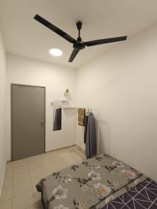 Un dormitorio con ventilador de techo y una cama. en UMMI HAWA Homestay, en Kampong Jelatang 2 fotos más