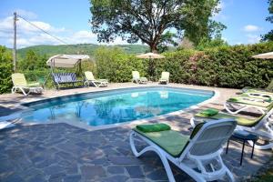 a swimming pool with chairs and umbrellas at Agriturismo Vinci in Gaiole in Chianti