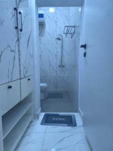 a bathroom with a shower and a toilet at The White Residence, Jabi, Abuja in Abuja +90 photos