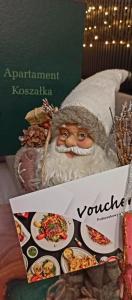 ein Bild vom Weihnachtsmann mit Tellern voller Essen in der Unterkunft Apartament Koszałka in Łeba