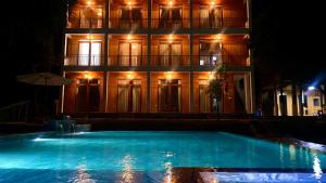 a building with a swimming pool in front of a building at night at Meadow Mai Chau Homestay in Mai Chau