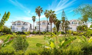 una fila de edificios blancos con palmeras en La Benata Beach Hotel, en Manavgat