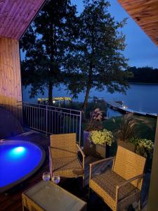 a patio with two chairs and a pool at night at Panacea in Lazdijai