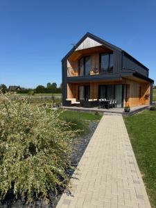 a black house with a walkway in front of it at Panacea in Lazdijai