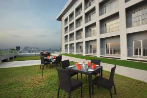 a patio with tables and chairs in front of a building at Starlit Suites Kochi in Cochin