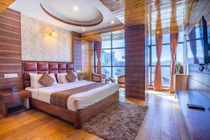 een slaapkamer met een groot bed en een groot raam bij Yashshree Jai Hotel & Banquet in Darjeeling +49 foto's