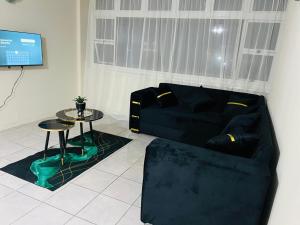 a living room with a black couch and a table at Kingsview, Margate in Margate