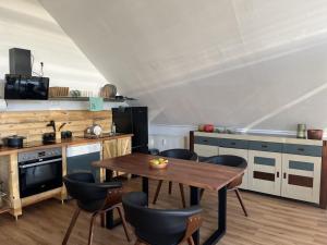 a kitchen with a wooden table and some chairs at NEU! Ferienwohnung Bottelterberg in Saarburg