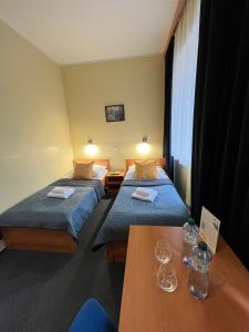 una habitación de hotel con dos camas y una mesa en Parkhotel Terezín, en Terezín