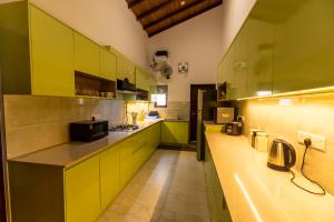 cocina grande con armarios amarillos y verdes en The Beach Home, en Galle