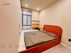 een kleine slaapkamer met een bed en een raam bij Bi Home in Phú Mỹ