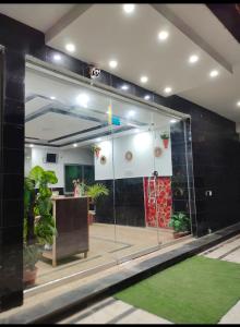 ein großes Glasfenster in einem Zimmer mit Pflanzen in der Unterkunft ALZAHIR Hostel & Rooms in Islamabad