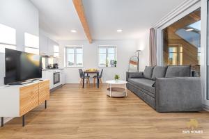 una sala de estar con un sofá y una mesa en SMS-Homes I Auszeit am See #1, en Waltenhofen