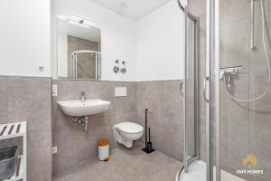 Un baño con lavabo, inodoro y ducha. en SMS-Homes I Auszeit am See #1, en Waltenhofen 20 fotos más