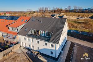 una vista aérea de una casa blanca con techo naranja en SMS-Homes I Auszeit am See #1, en Waltenhofen