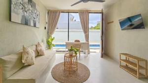 een woonkamer met een bank en een tafel bij KAYA Uluwatu in Uluwatu