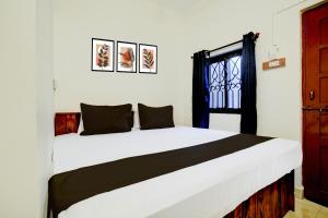 a bedroom with a large white bed with a window at Hotel O by OYO Shoreline Horizon Hideaway in Anjuna