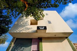 ein hohes weißes Gebäude mit einem Schild darauf in der Unterkunft Hotel O Hajipur Bus Terminal Formerly New Urvashi in Sonpur
