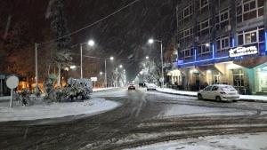 Una calle nevada con coches circulando por ella en Hôtel chahrazad, en Imouzzer Kandar