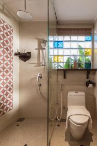 a bathroom with a toilet and a glass shower at Seahorse Tropical Da Nang Hotel by Haviland in Da Nang