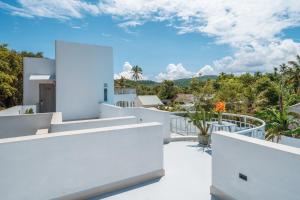 a view from the balcony of a house with white walls at The Up Hotel Phu Quoc Island - The Poolside Escape in Phu Quoc