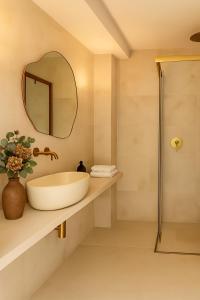 een badkamer met een wastafel en een spiegel bij Hotel Boutique Petit París in Port de Pollença