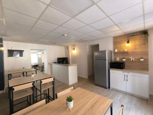 eine Küche und ein Esszimmer mit Tischen und einem Kühlschrank in der Unterkunft Central Hôtel in Cerbère + 2 Fotos