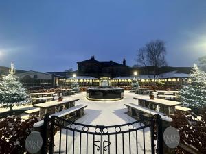 a courtyard with benches and a fire pit in the snow at Dean Park Hotel in Kirkcaldy