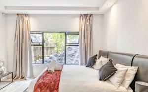 een slaapkamer met een bed en een groot raam bij CAPE20 Villa in Kaapstad