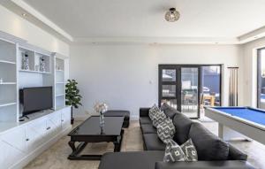 een woonkamer met een bank en een pooltafel bij CAPE20 Villa in Kaapstad