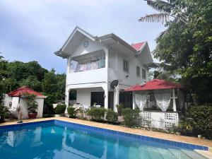 a house with a swimming pool in front of it at Panglao Budget Staycation & Guesthouse For Family ,Groups, and Friends in Panglao Island