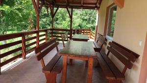 eine Veranda mit einem Holztisch und Bänken darauf in der Unterkunft LaBrazi in Şimon