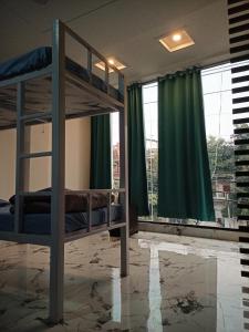 a bedroom with two bunk beds with green curtains at Leesha Tower - Dormitory in Jhānsi +5 photos
