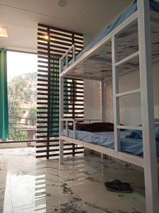 a bedroom with bunk beds in a room with a window at Leesha Tower - Dormitory in Jhānsi