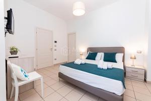 a bedroom with a bed and a desk and a chair at Mama Bed in Porto Cesareo +2 photos