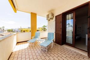 a balcony with two chairs and a table on it at Mama Bed in Porto Cesareo