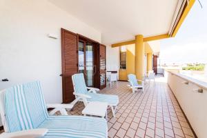 a balcony with blue and white chairs and a counter at Mama Bed in Porto Cesareo