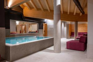 eine große Badewanne in einem Raum mit einem Spiegel in der Unterkunft Le Sort Mountain Retreat in Passo del Tonale