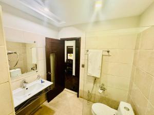 a bathroom with a sink and a toilet and a shower at Bling International Hotel Multan in Multan +30 photos